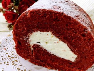 红丝绒蛋糕#乐享双节#,定型好的蛋糕卷里抹多点奶油再卷起来，哦哦，好肥的卷啊，所以奶油适当也要厚一些，在表面洒些糖粉