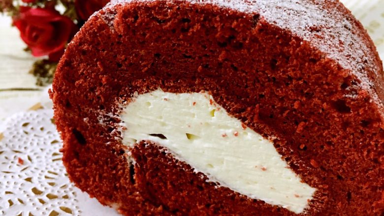 红丝绒蛋糕#乐享双节#,定型好的蛋糕卷里抹多点奶油再卷起来，哦哦，好肥的卷啊，所以奶油适当也要厚一些，在表面洒些糖粉