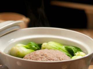 清蒸狮子头,隔水蒸40分钟，再将油菜芯放入，蒸5分钟，汤中撒少许白胡椒粉即可。