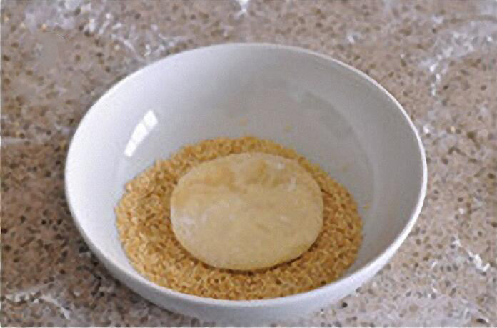 油酥烧饼：酥香暖胃治愈系主食,全部做好后，用毛刷在饼胚表面刷清水，刷到有点儿黏黏糊糊后粘上一层芝麻。