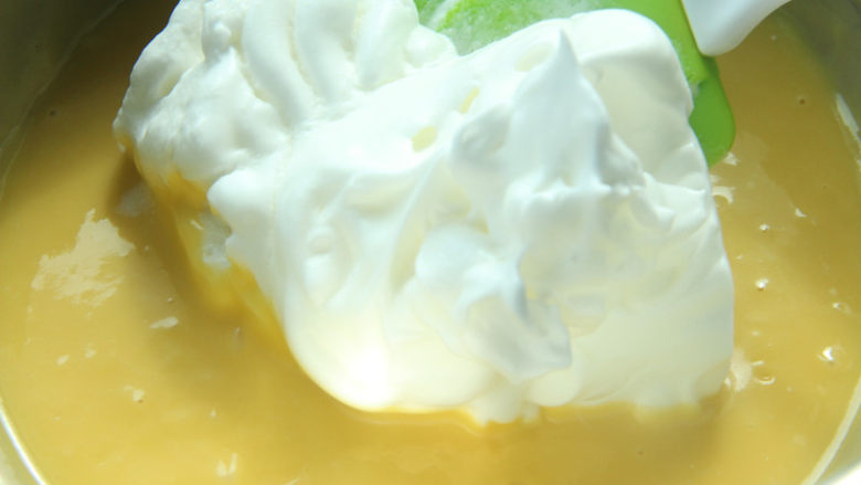 熔岩夹心蛋糕,取三分之一蛋白放入蛋黄糊中拌匀。