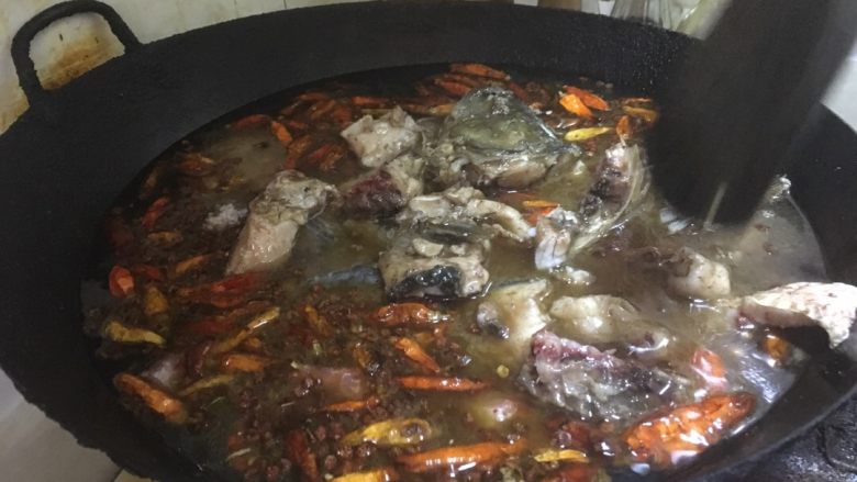 正宗湘菜 片片鱼火锅,当花椒微微发黑。干辣椒微微发黑。香味出来之后。就可以加水入锅了。入水后。将煎好的鱼骨放入锅内。