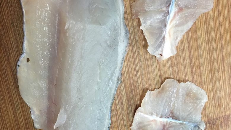 清新版酸菜鲈鱼,切成鱼片，这里要注意的，带皮！因为肉食鱼类鱼肉熟了是片状，否则就散了