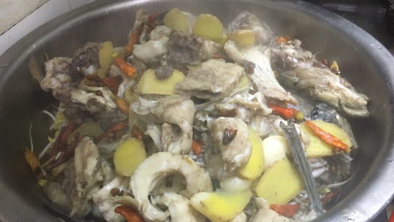 正宗湘菜 片片鱼火锅,把锅子里煮的鱼骨捞出，放在铺满豆芽的大盆里
