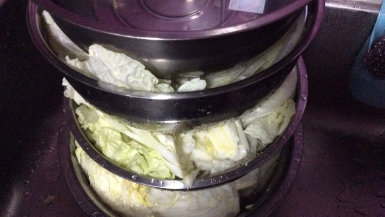 韩国辣白菜,每颗撒完盐后，摆在盆里加水莫过白菜用重物压上，压15个小时