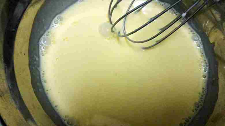 零失败葡式蛋挞,蛋黄加入混合液中，使用打蛋器打匀，得到有泡泡蛋挞液，使用筛子过滤。