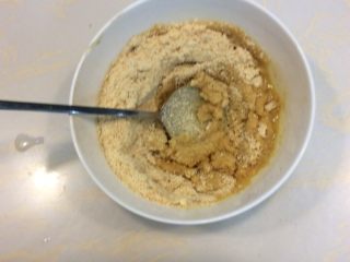 改良版提拉米苏,打碎的指拇饼干倒入 融化的黄油液中搅拌均匀。