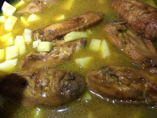 咖喱鸡翅焖饭,1、将切好的土豆丁倒入锅中，加入咖喱粉翻炒
2、倒入适量开水