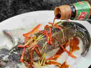 #年夜饭#清蒸鲈鱼,将蒸鱼豉油淋在鱼上，放上葱节。