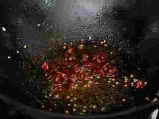 #年夜饭#炒年糕,干辣椒切节，锅中油热后将辣椒炒熟。