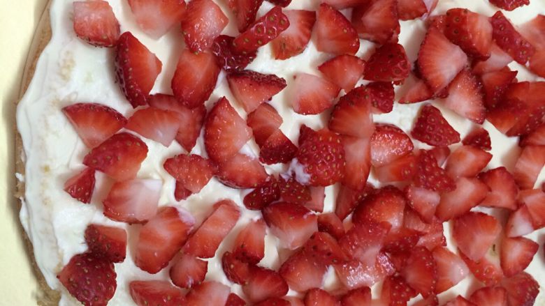 草莓奶油蛋糕,抹平后，重复做第9步骤，用打发好的奶油放草莓粒上抹平