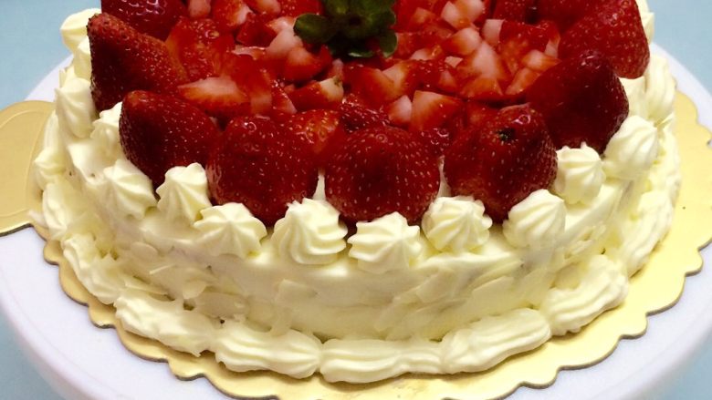 草莓奶油蛋糕,抹完、抹平整个蛋糕后，把剩下的草莓装饰好，把扁桃仁放烤箱烤一分钟拿出，烤一下会让扁桃仁更脆点，之后撒在蛋糕的侧旁，整个做好后，放冰箱再冰1-2个小时就可以吃了