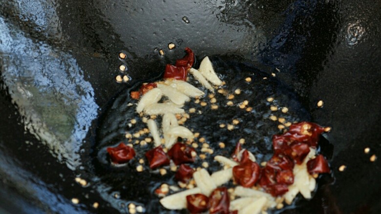 麻辣莴笋丝#春意绿#,锅中油热后，放入辣椒和大蒜爆香。
