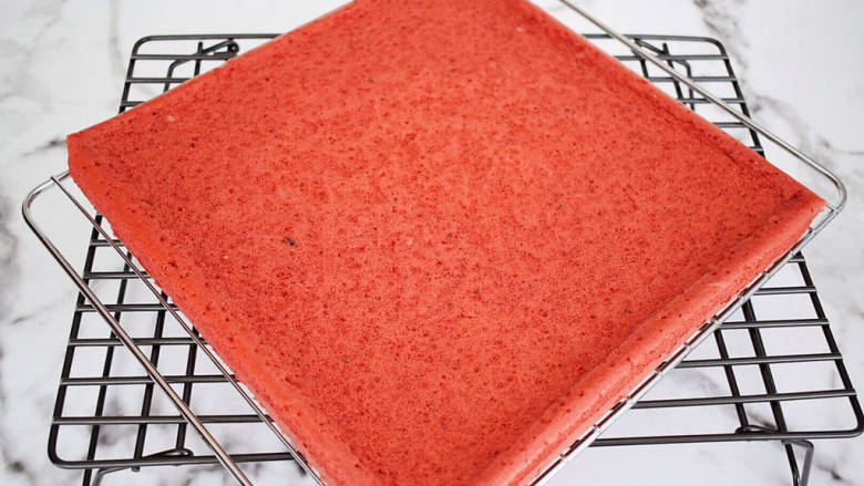 红曲蛋糕卷,烤好马上取出震一震，然后倒扣在烤网上，轻轻撕掉油纸晾至余温