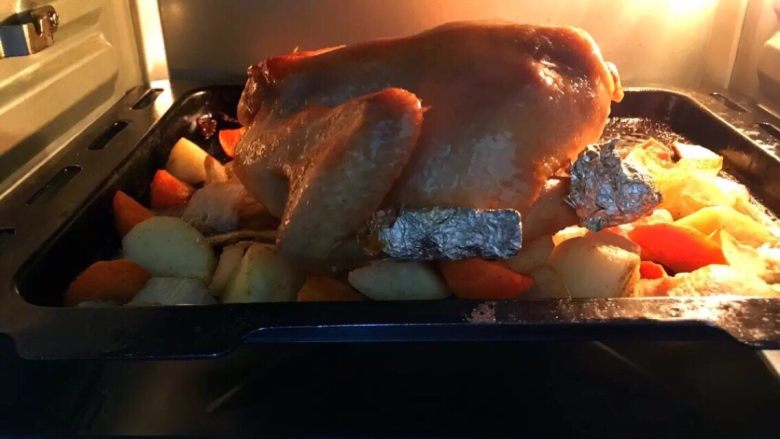 金鸡送福～烤鸡,半小时后将鸡拿出来将剩余的调料刷在鸡身上，将鸡翻过来继续200度上下火烤半小时
