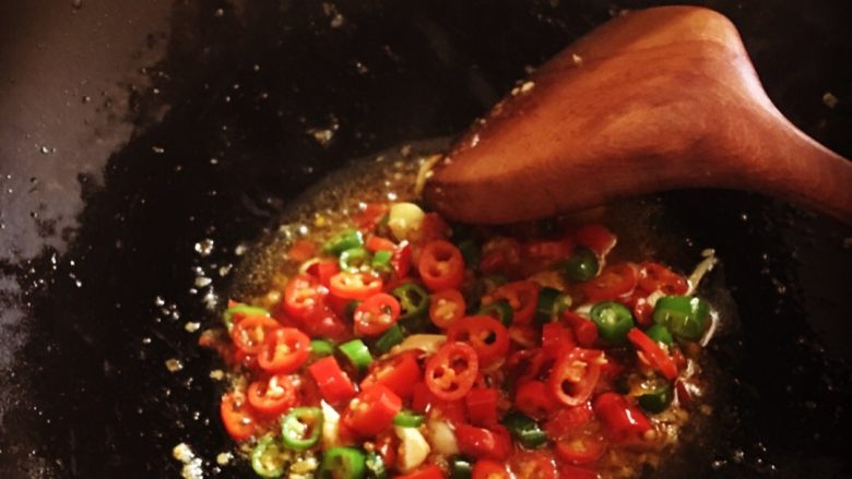 鸿运当头,青红辣椒炒香出锅，将蒜末和剁辣椒那些平铺在鱼头上。