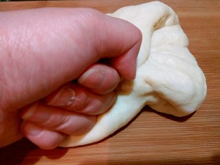 椰蓉蔓越莓面包,把发酵好的面团揉一下排气。