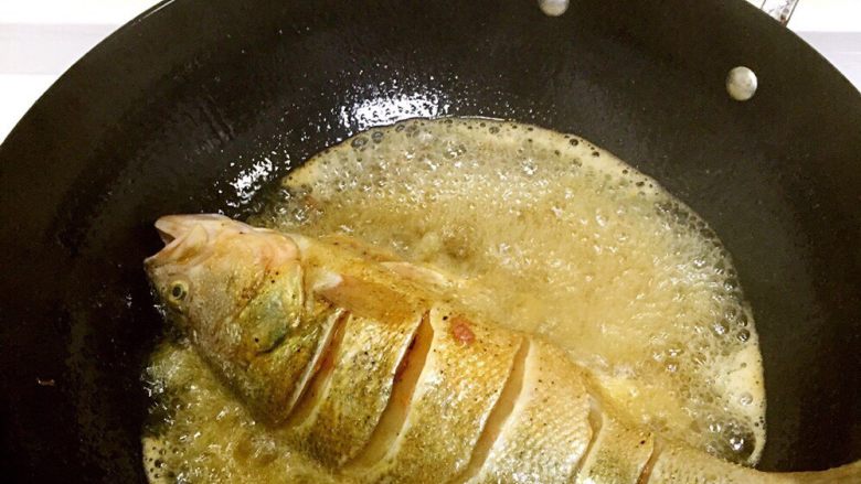 烤鲈鱼,开油锅，把鲈鱼炸一遍
