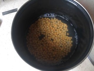 豌豆黄夹心巧克力慕斯,去皮的豌豆放奶锅里加水，泡三四个小时以上，水要超出豌豆一倍高