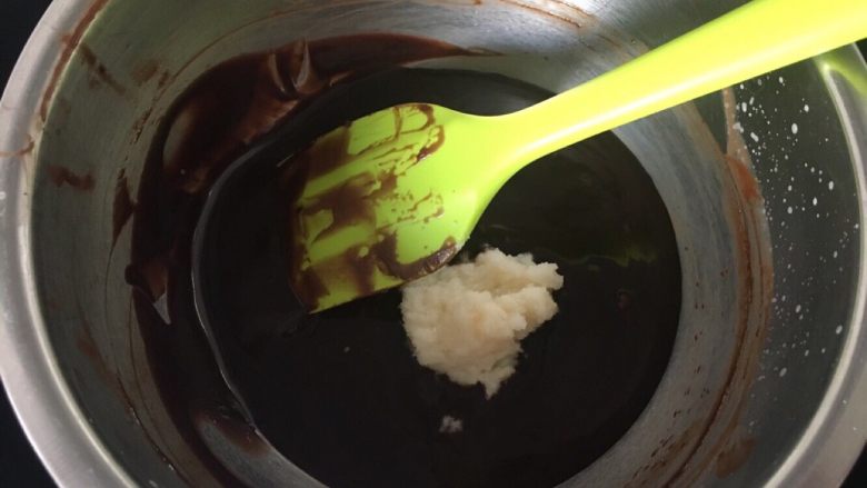 豌豆黄夹心巧克力慕斯,搅拌均匀后把用牛奶泡好的吉利丁倒入黑巧克力糊，搅拌融化