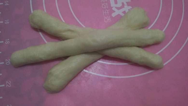 麻花辨面包,取出其中一小块面团分成3小份，搓成长条，编成麻花的形状。