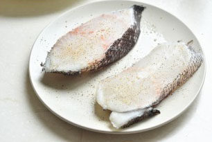 香煎杏仁鳕鱼,在鳕鱼的两面均匀地撒上盐和胡椒粉；
