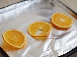 香橙烤鸡腿,切三片橙子，放在烤盘上（烤盘上铺上锡纸）