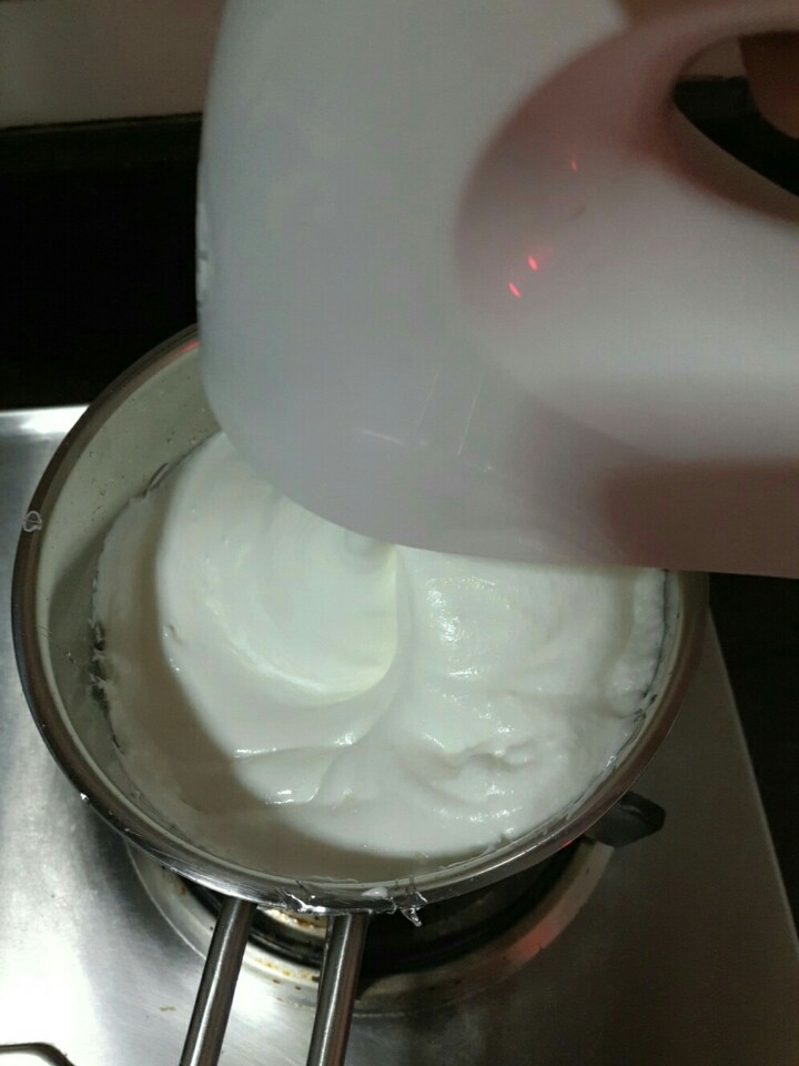 抹茶白巧牛轧糖,糖浆熬好，蛋白打发好，就把蛋白倒进糖浆里面，打蛋器用最大档搅打，这个过程大概3分钟左右，打到打蛋器明显感觉到阻力，就可以停止，把黄油巧克力混合液分2-3次加入到糖浆里面，每次加入都要用打蛋器充分搅打
(最开始的25g白糖可以分10g加入到蛋白里面一起打发，可以增加蛋白的稳定性)