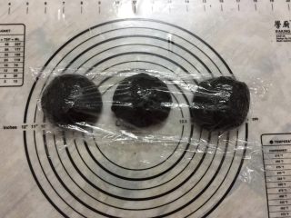 黑可可热狗包,把发好的面团轻拍排气，平均分割成3个面团，分别揉圆，盖保鲜膜松弛15分钟。