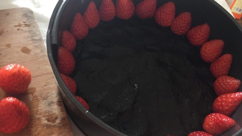 草莓🍓冻芝士蛋糕🍰,草莓头切掉，然后对半切，按照图片一个个码在蛋糕模的边缘。（草莓一定要紧贴模壁；选小草莓，尽量一样高。）然后把蛋糕模放入冰箱（我放的零度保鲜）