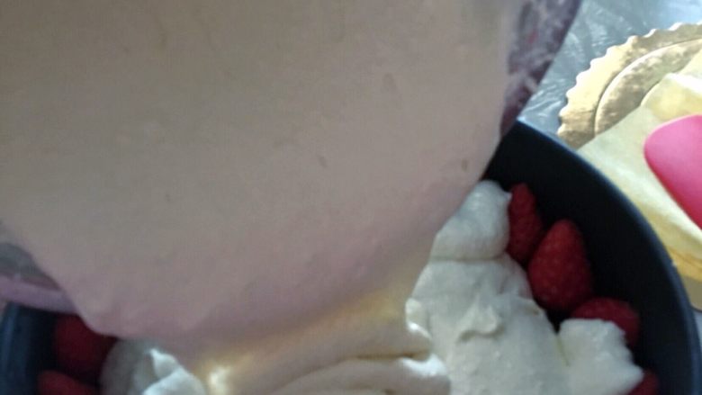 草莓🍓冻芝士蛋糕🍰,模子从冰箱拿出来，把慕斯液倒入里面，完全盖过草莓，中间可以撒点切好的草莓丁。保鲜膜封好，放入冰箱里。冷藏至少五小时。（最好提前一天做好，冷藏过夜更能凝固）