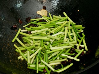 蒜苔肉丝#春意绿#,辣椒微糊放入蒜苔，炒至断生。