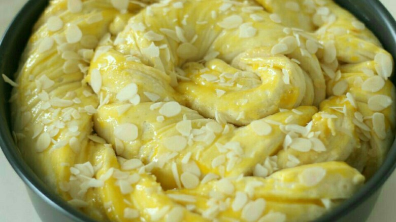 香草杏仁面包,二发发酵到8分满。表面刷蛋黄，撒杏仁片。