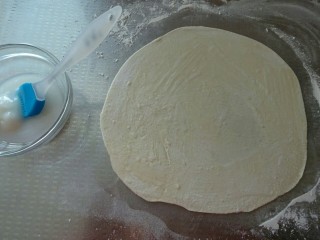香酥葱花饼,取一份面团，按扁、擀成薄片，刷上一层猪油（尽量薄一点哦，这样卷起来才会层次多，口感好）