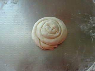 香酥葱花饼,从一头盘起来，边抻边盘，尾部压在下面，按扁