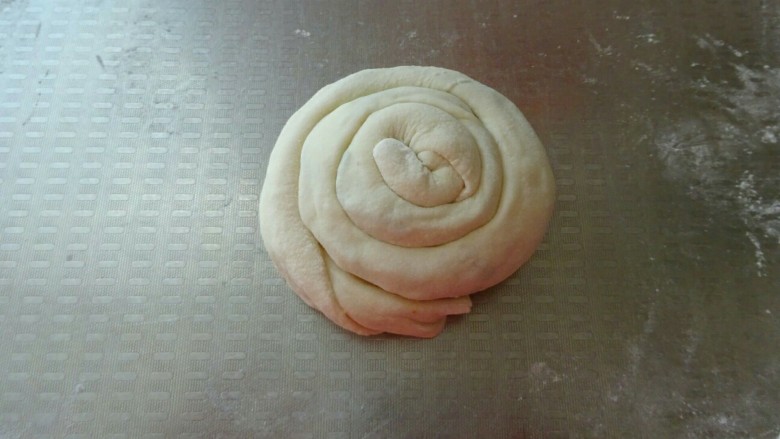 香酥葱花饼,从一头盘起来，边抻边盘，尾部压在下面，按扁