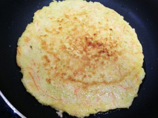虾皮角瓜胡萝卜丝蛋饼,轻轻晃动不粘锅饼动了，表面干了就可以翻面了。