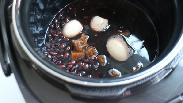 滋补甜汤——黑豆红糖炖蛋,剥好的鸡蛋和红糖放进煮好的黑豆里