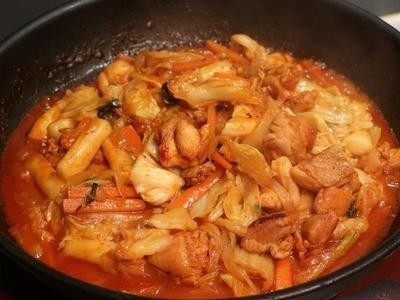 辣炒起司春川鸡,加入韩式年糕，加入水，盖锅盖闷煮至年糕软化