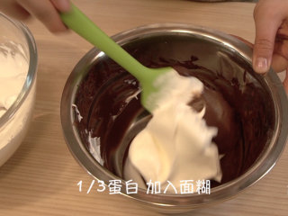 可可戚风 巧克力围边奶油蛋糕（视频菜谱）,倒入剩余细砂糖，最终打发后，提起打蛋头，有不下垂的尖尖角，将1/3蛋白霜加入到面糊里，翻拌均匀（不要画圈搅拌）