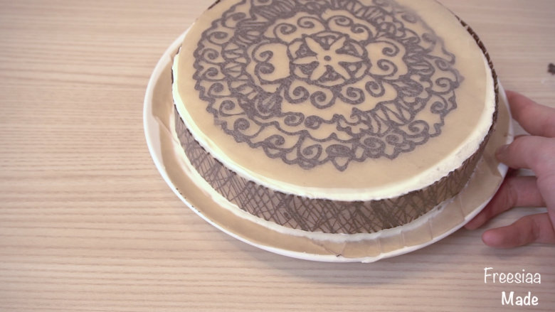 可可戚风 巧克力围边奶油蛋糕（视频菜谱）,等巧克力稍凝固，但没有完全变硬时，把花纹粘在蛋糕上，再放入冰箱冷藏5-10分钟