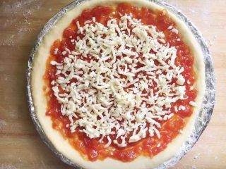 意式四季披萨,再铺一层奶酪碎。