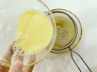 宝宝辅食：水果蛋奶布丁-12M+,将步骤2中准备好的鸡蛋牛奶液过筛，可以多过筛一次哈，过筛后成品口感会更加细腻哦，过完筛后倒入蒸碗中。
》如果不过筛，蒸完后成品表面会不光滑哈。