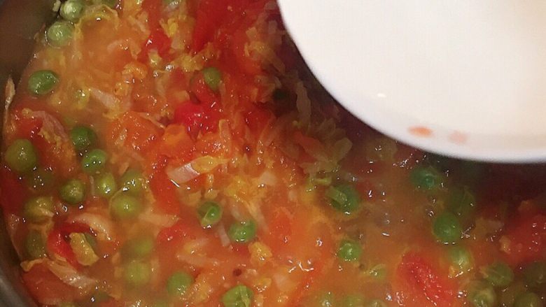番茄豌豆盖浇饭,直至锅盖上蒸汽后转小火，开盖，翻炒下，如果汤汁儿少可以加少许水再焖会儿