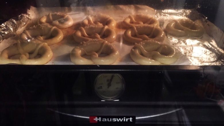 危险与美味并存一一德国碱水包,将普雷结放入烤箱，朝烤箱喷洒一些蒸汽，上下火15－20分钟（变成棕红色）