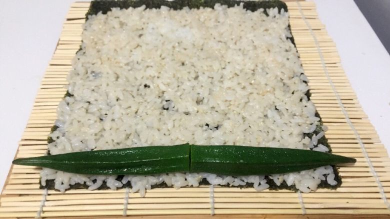 酱香味秋葵寿司（纯素版）,放两根秋葵在米饭一端，用竹席卷上一点