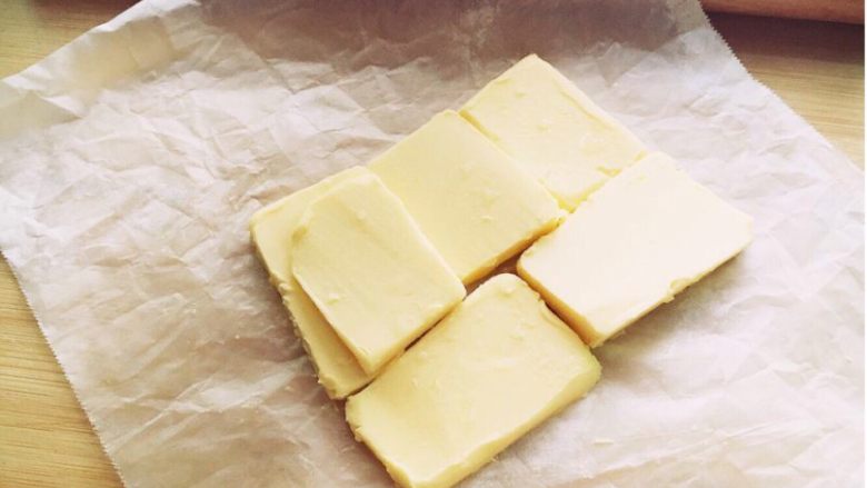可颂～法式羊角面包,准备一张油纸，将黄油切片摆入。