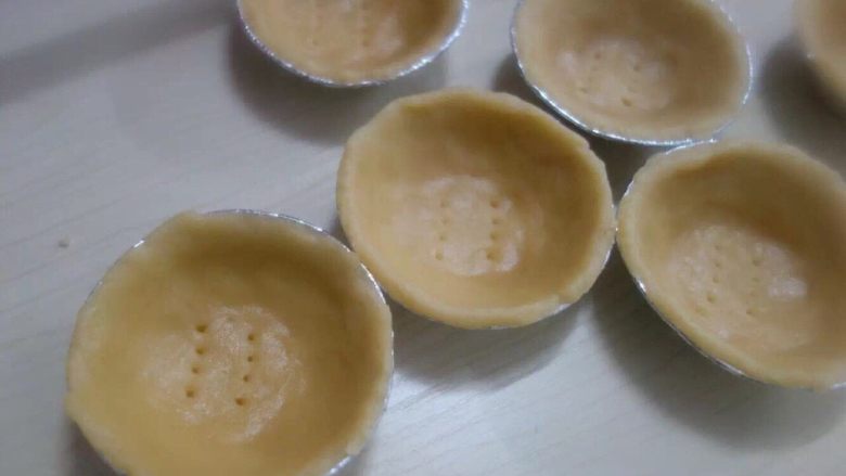 在家轻松做港式蛋挞,挞皮取出，薄薄的一层按进模具，在底部戳些小洞洞。