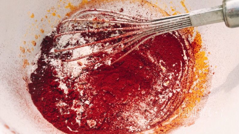 怎么拍都美的红丝绒蛋糕,筛入蛋糕粉和红曲粉，用蛋抽由下往上翻拌均匀，直到完全融合，没有干粉。