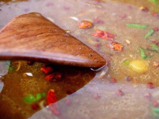 鱼头锅片片#烟台特色#,炒香后的材料加入适量清水、加入白糖、料酒、鸡精、盐调味